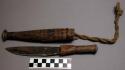 Sheath containing knife - hand hewn, small pattern on side, rope attachment ("gi