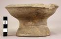 Grey earthenware hollow pedestalled bowl with traces of yellowish- +