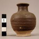 Small smooth dull-glazed brown jar - not entirely glazed;