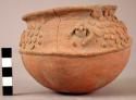 Small red pottery bowl with applique designs around neck