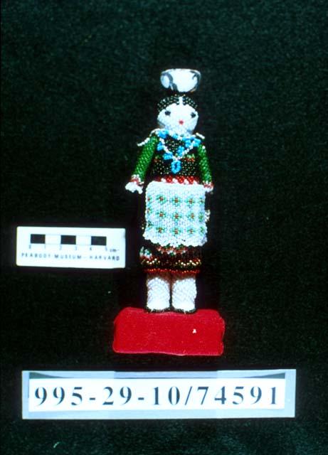 Beaded female doll with ceramic pot on her head