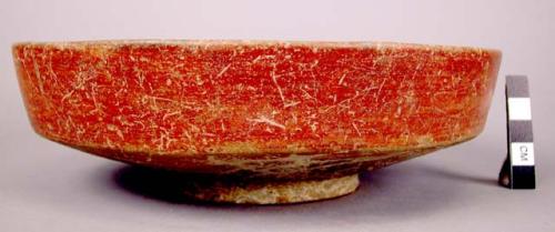 Shallow ring base bowl of buff ware with red slip