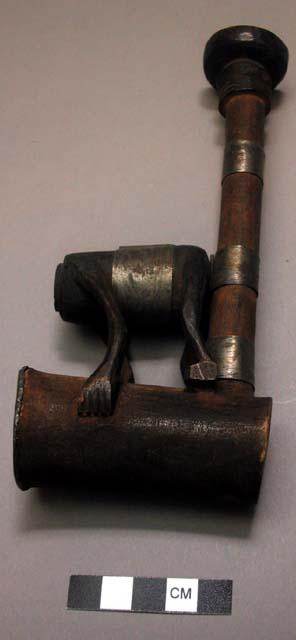 Wooden pipe with figure sitting on stem (figure has no head); metal top on bowl;