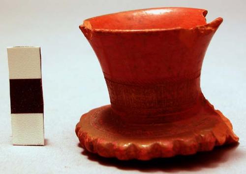 Broken red pottery pipe with incised design