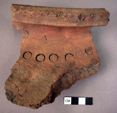 Part of rim of large red jar with small stamped circles near the rim