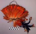 Hat - woven fibre covered with orange feathers, top knot of orange & +