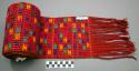 Woman's belt. red with brown and white stripes, embroidery in green, blue, yello