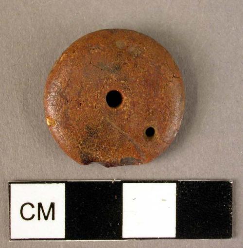 Disk-shaped amber pendant or bead, with central hole